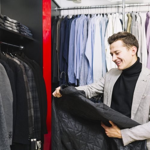 happy-handsome-man-looking-jacket-clothes-shop